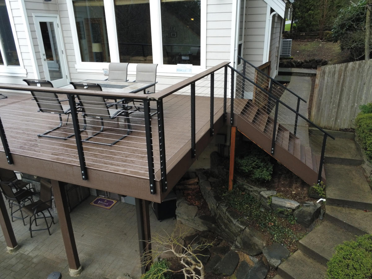 Covered under-deck grill and bar area, Trex composite decking, and cable railing in Redmond, WA