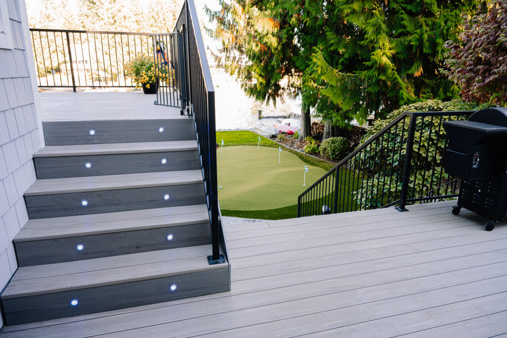 horizontal steel rod railing on stairs with stair lighting on composite decking 