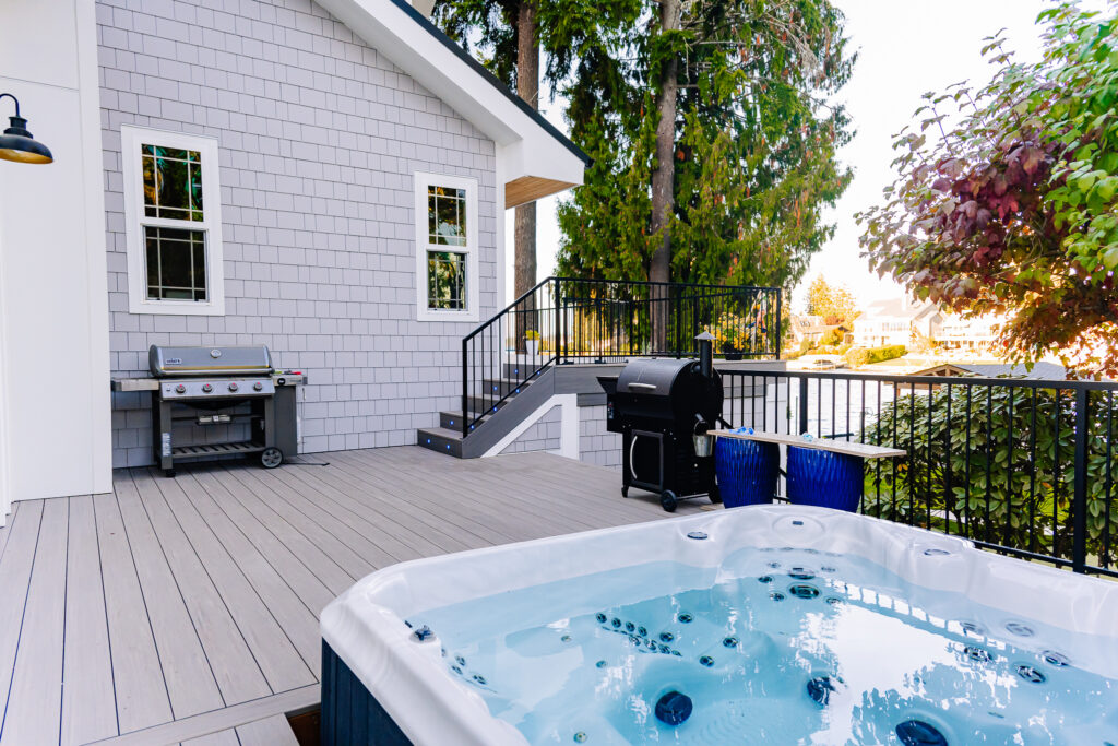 horizontal steel rod railing on composite decking with siding on house and built in deck jacuzzi hot tub