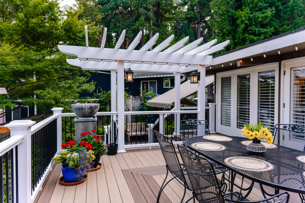 Vertical surface mount black post white rail composite railing with two tone Azek Decking and pergola