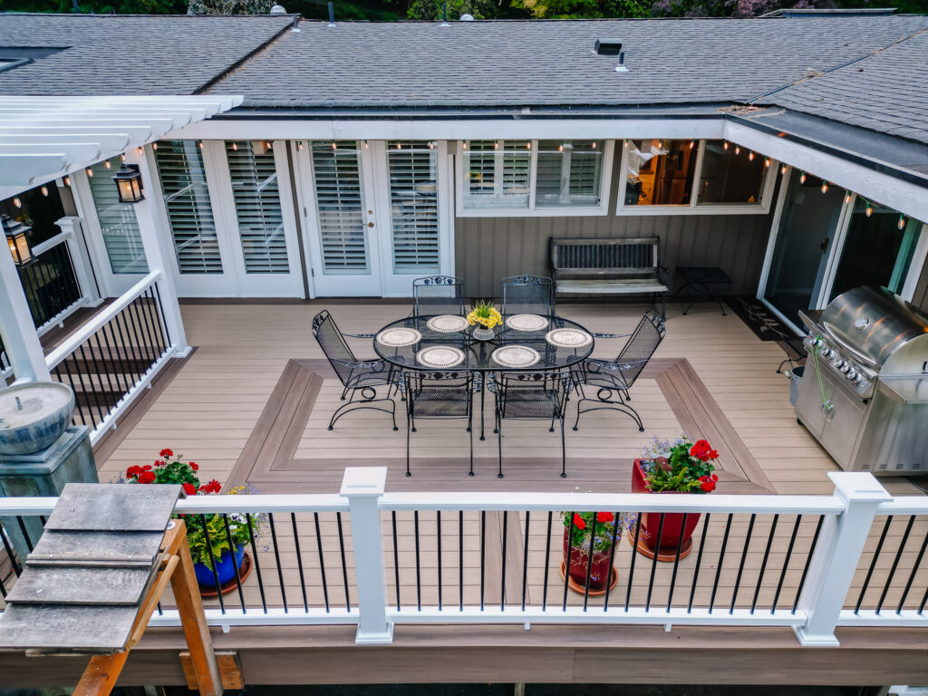 Vertical surface mount black post white rail composite railing with two tone Azek Decking and pergola