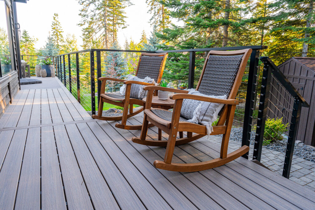 Wrap around deck with wooden rocking chairs surrounded by nature